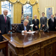 President Donald Trump signs executive orders in the Oval Office on Jan. 23, 2017. (Ron Sachs/pool photo via Bloomberg News)
